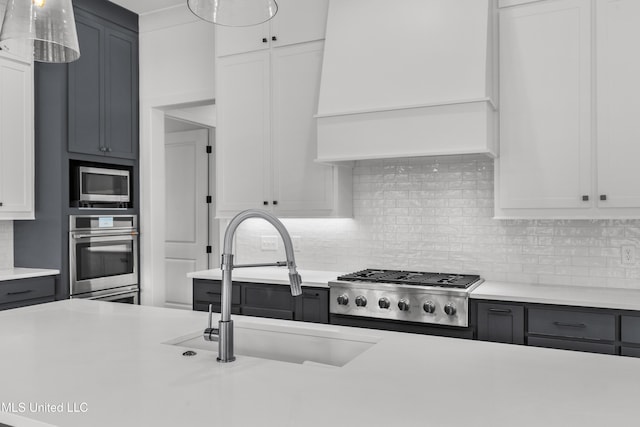 kitchen with light countertops, appliances with stainless steel finishes, backsplash, and white cabinets