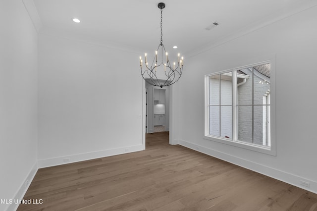 unfurnished dining area featuring ornamental molding, visible vents, baseboards, and wood finished floors