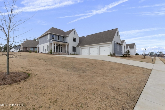 view of front facade with a garage, concrete driveway, and a front yard