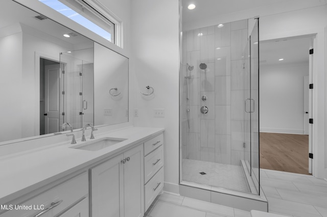 bathroom with visible vents, a stall shower, vanity, and baseboards