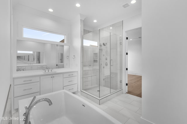 bathroom with recessed lighting, visible vents, a freestanding bath, a stall shower, and vanity