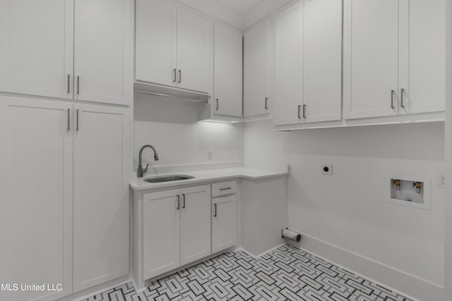 washroom with cabinet space, baseboards, hookup for a washing machine, hookup for an electric dryer, and a sink