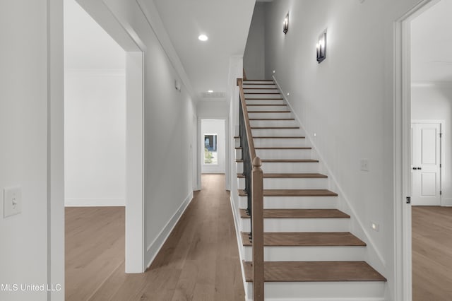 staircase with ornamental molding, recessed lighting, baseboards, and wood finished floors