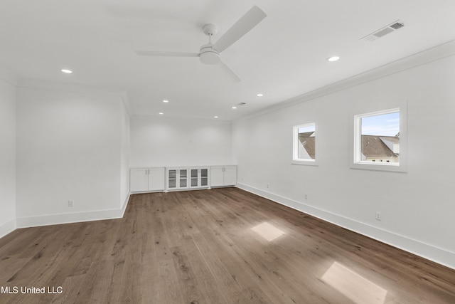 unfurnished room with ornamental molding, baseboards, and wood finished floors