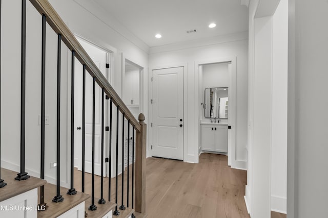 entryway featuring visible vents, stairway, ornamental molding, light wood-style floors, and recessed lighting