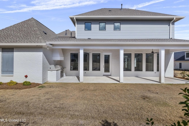 back of house with a yard, exterior kitchen, a patio area, and brick siding