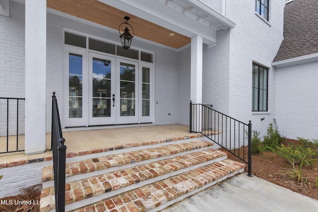 entrance to property featuring french doors and brick siding