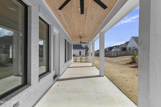 view of patio / terrace featuring a residential view, fence, and a ceiling fan