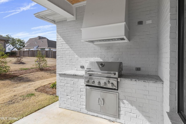 view of patio with area for grilling, a grill, and fence