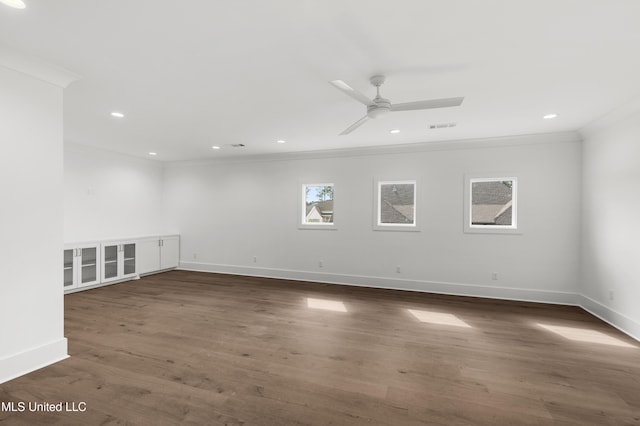 spare room featuring ornamental molding, dark wood-style flooring, visible vents, and baseboards