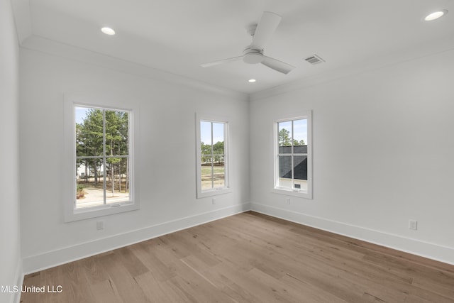 empty room with light wood finished floors, baseboards, and visible vents