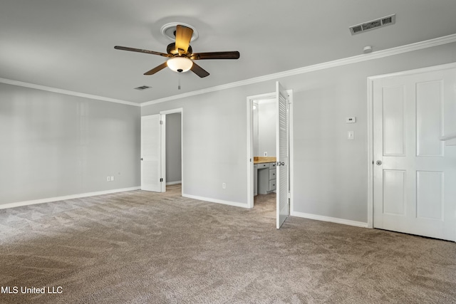 unfurnished bedroom featuring carpet, ensuite bathroom, ceiling fan, and crown molding