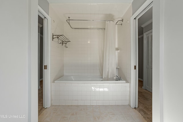 bathroom with shower / bath combo with shower curtain and tile patterned flooring