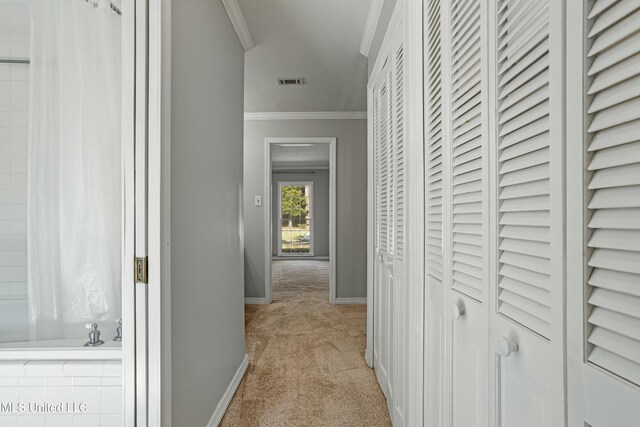 hallway featuring crown molding and light carpet