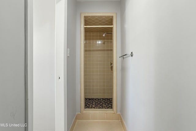 bathroom featuring tile patterned floors and a tile shower