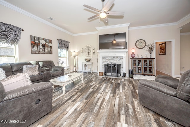 living room featuring ceiling fan, a fireplace, wood-type flooring, and ornamental molding