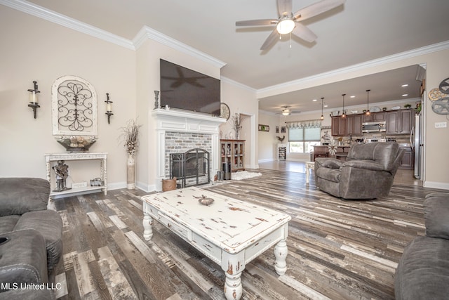 living room with dark hardwood / wood-style flooring, ceiling fan, a fireplace, and ornamental molding