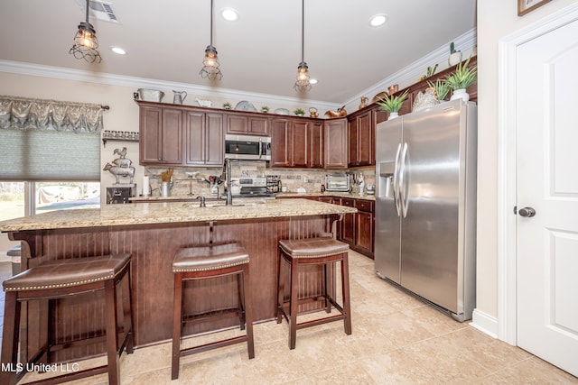 kitchen with light stone counters, dark brown cabinets, decorative light fixtures, and appliances with stainless steel finishes