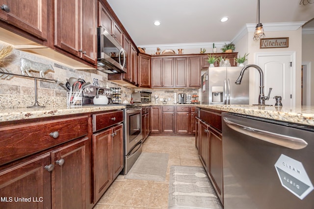 kitchen with tasteful backsplash, light stone counters, ornamental molding, stainless steel appliances, and hanging light fixtures