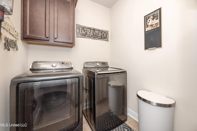 laundry area with cabinets, washing machine and dryer, and tile patterned floors