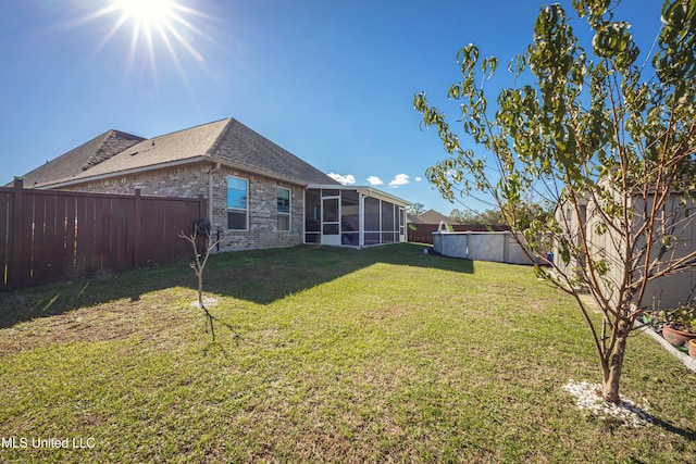 view of yard featuring a sunroom and a swimming pool