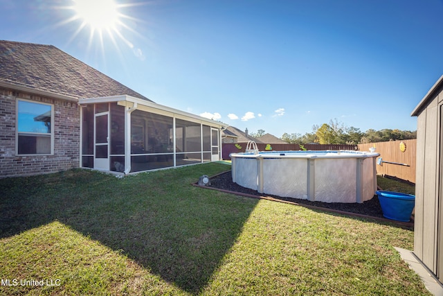 view of yard featuring a sunroom and a fenced in pool