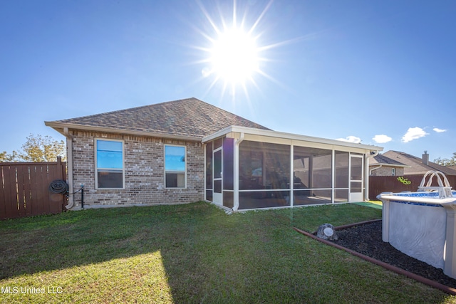 rear view of house with a sunroom and a yard