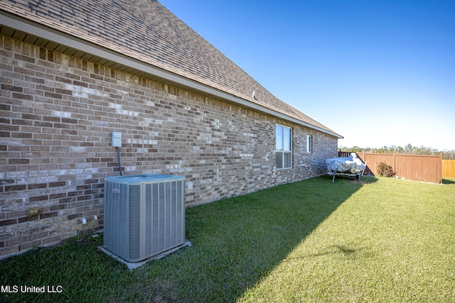 view of side of home featuring a lawn and central air condition unit