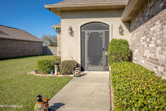 entrance to property featuring a lawn