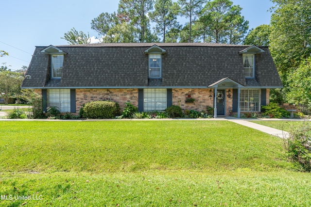 cape cod home with a front lawn