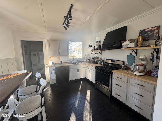 kitchen featuring stainless steel gas range oven, extractor fan, black dishwasher, freestanding refrigerator, and open shelves