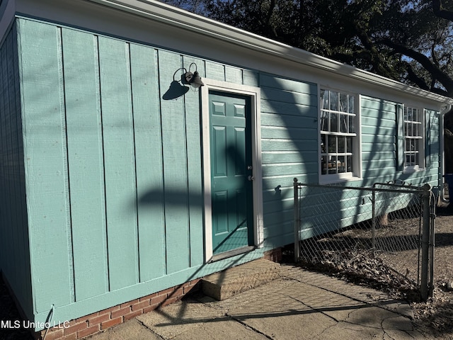 doorway to property with fence and board and batten siding