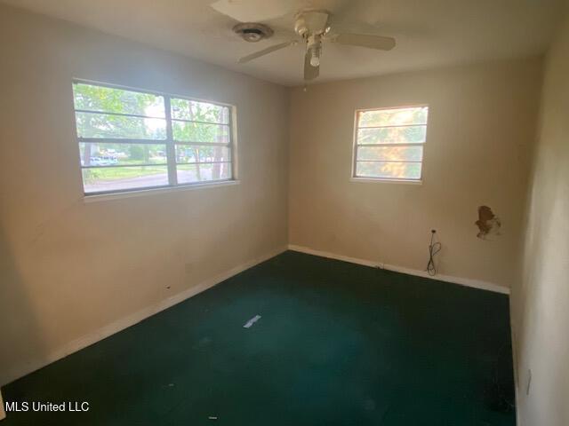511 Forest Ave, Jackson, MS 39206 - spare room featuring healthy amount of natural light, dark colored carpet, a ceiling fan, and baseboards