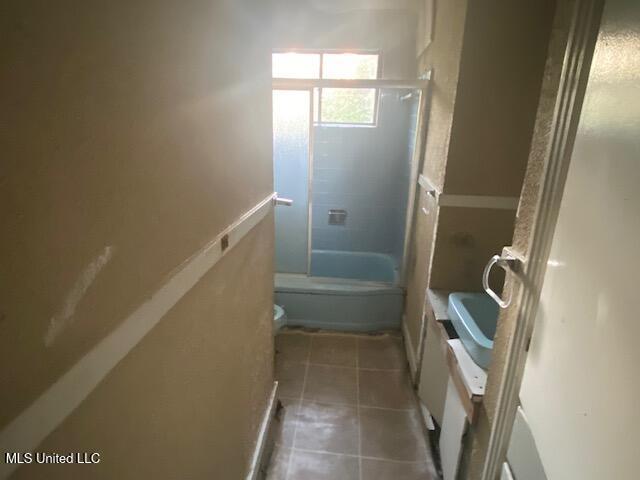 511 Forest Ave, Jackson, MS 39206 - bathroom featuring toilet, tile patterned flooring, and bathing tub / shower combination