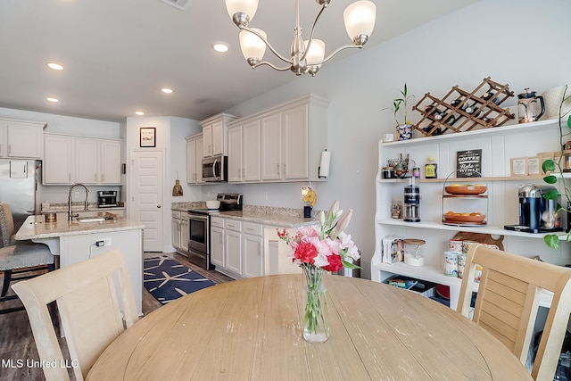 dining area with a chandelier, dark wood-type flooring, and recessed lighting