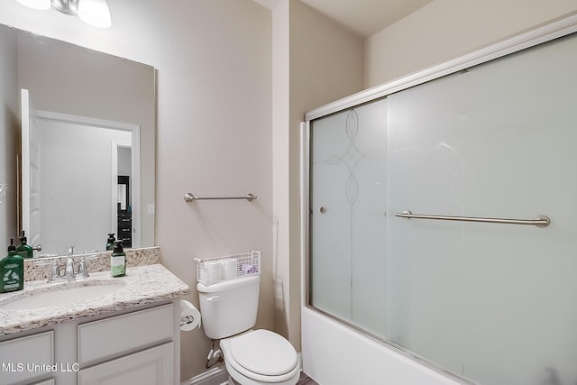 bathroom with toilet, combined bath / shower with glass door, and vanity