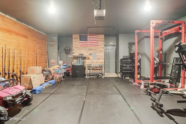 garage featuring a garage door opener and wooden walls