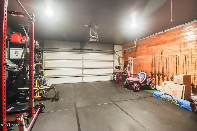 garage with wood walls and a garage door opener