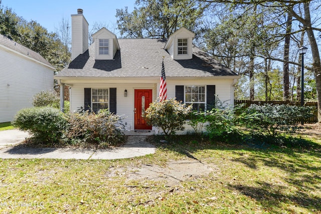 cape cod house featuring a front yard, roof with shingles, and a chimney