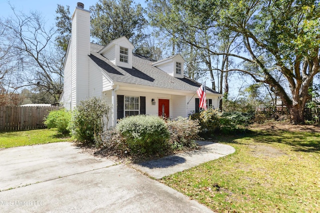 cape cod home featuring a chimney, roof with shingles, a front lawn, and fence