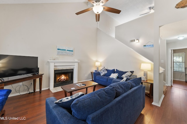 living room with visible vents, high vaulted ceiling, a ceiling fan, wood finished floors, and a tile fireplace