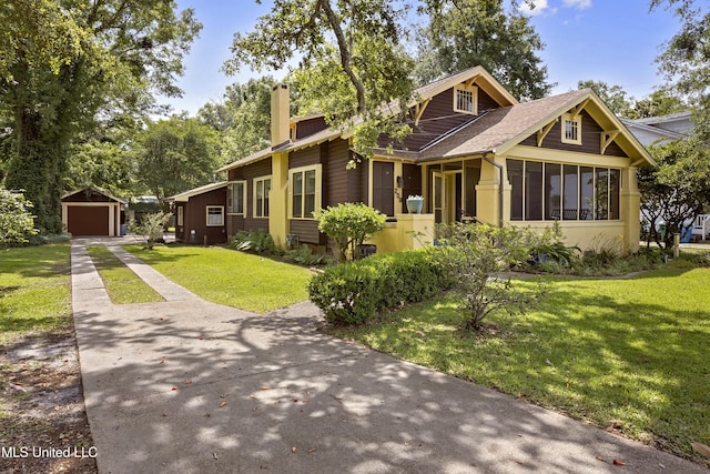 208 Washington Ave, Ocean Springs, MS 39564 - view of front of house with driveway, a sunroom, a garage, a chimney, and an outdoor structure