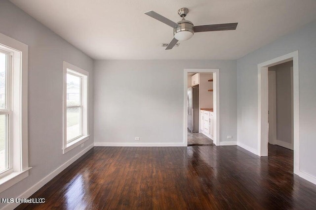 unfurnished room featuring dark wood-type flooring and ceiling fan