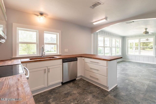 kitchen featuring stainless steel dishwasher, sink, white cabinetry, and plenty of natural light