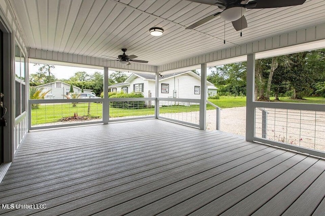 wooden deck featuring a lawn and ceiling fan