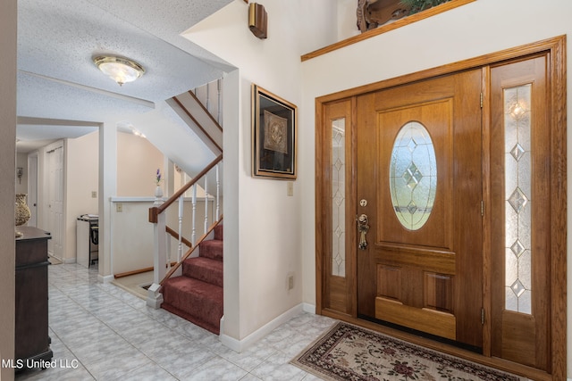 tiled entryway featuring a textured ceiling