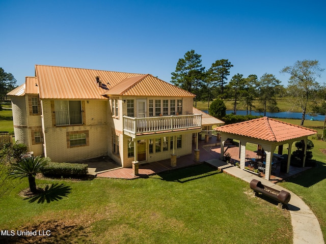 rear view of house featuring a gazebo, a patio area, and a lawn