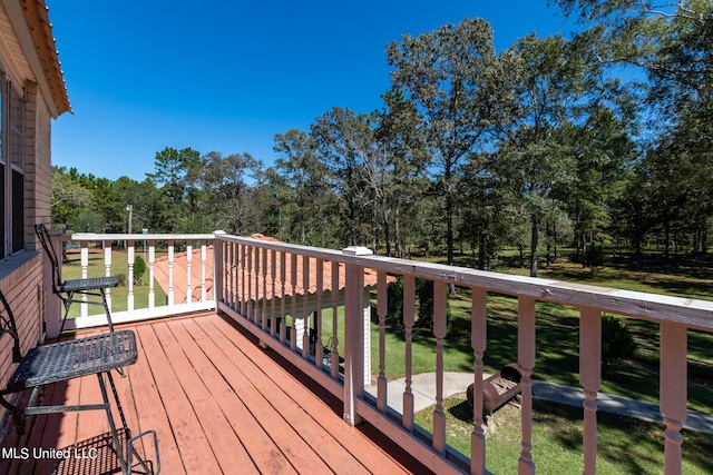 wooden terrace featuring a yard