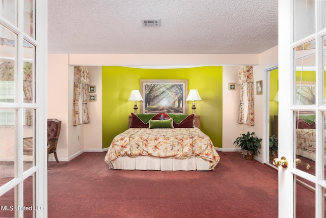 carpeted bedroom with french doors and a textured ceiling