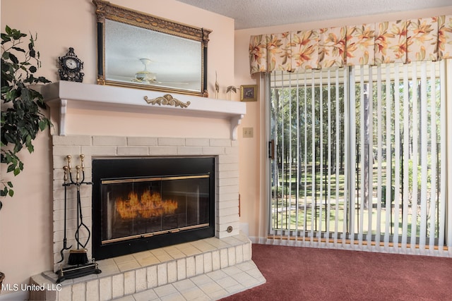 interior details with a brick fireplace, a textured ceiling, ceiling fan, and carpet floors